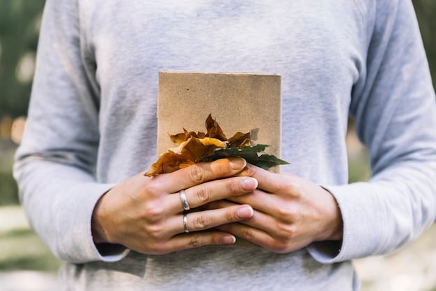 A hand holding a seed packet with soil, symbolizing plant-based packaging materials and their potential to return to the earth as compost. The background is a blurred image of a garden.