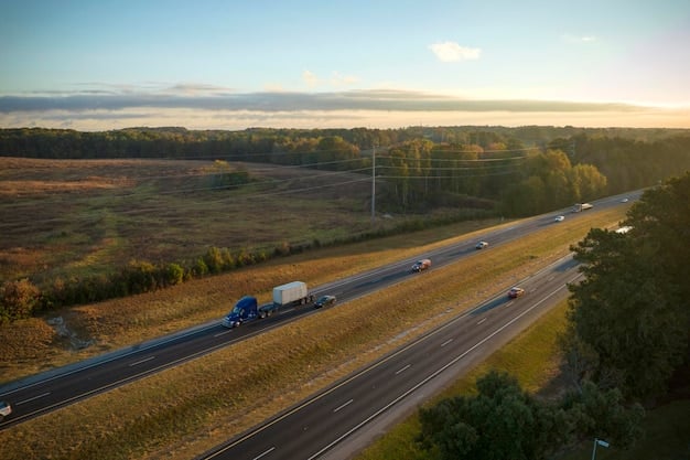 A busy highway during the day with several semi-trucks transporting goods in both directions. The road is well-maintained, and the sky is clear.
