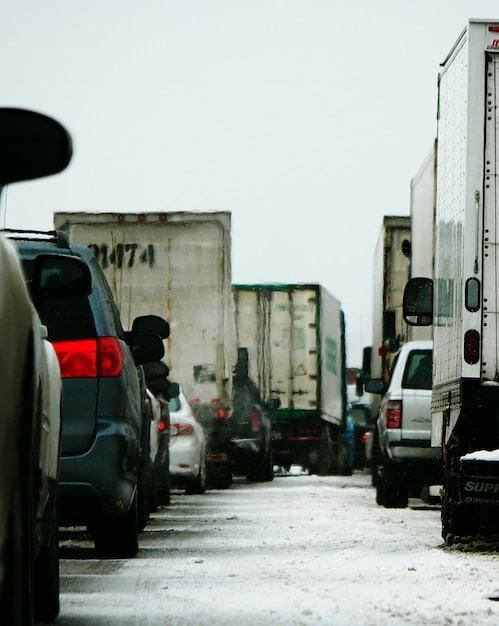 A gridlocked city street with delivery trucks stuck in traffic, highlighting the challenges of congestion in urban logistics.