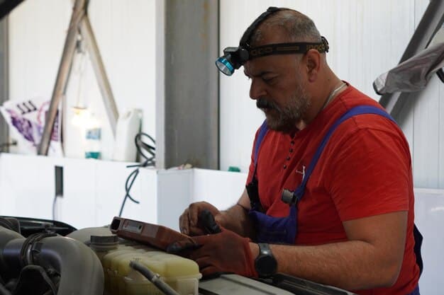 A technician performing routine maintenance on the battery pack of an electric delivery vehicle. The technician is wearing safety gear and using specialized tools.