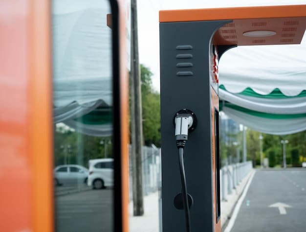 A close-up shot of a charging station connected to an electric school bus, highlighting the charging cable and the bus's electric port. The background shows a row of similar charging stations and other electric buses, emphasizing the scale of electric infrastructure implementation.