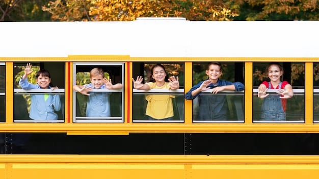 A group of elementary school children standing beside an electric school bus, waving and smiling, with the school building visible in the background. The atmosphere is cheerful and positive, suggesting the benefits and excitement associated with electric school buses.