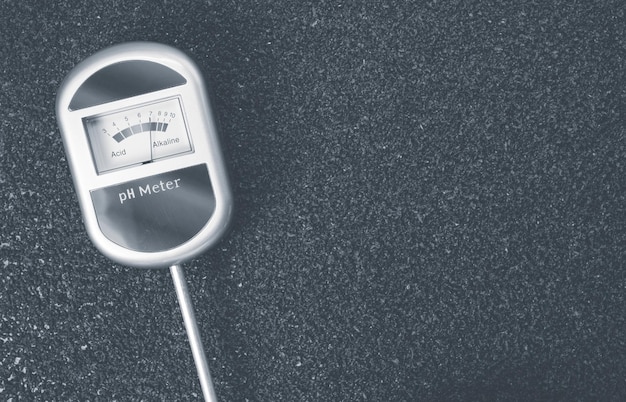 A close-up shot of a parking sensor embedded in asphalt, detecting a car parked above it. The sensor is sleek and unobtrusive, seamlessly integrated into the parking space. In the background, blurred city traffic moves by.