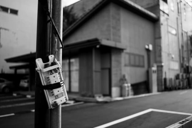 A close-up of a surveillance camera on a street corner in a smart city, with a blurred overlay of digital data flowing around it, symbolizing the constant collection and processing of information. The image should provoke thought about the balance between security and privacy.