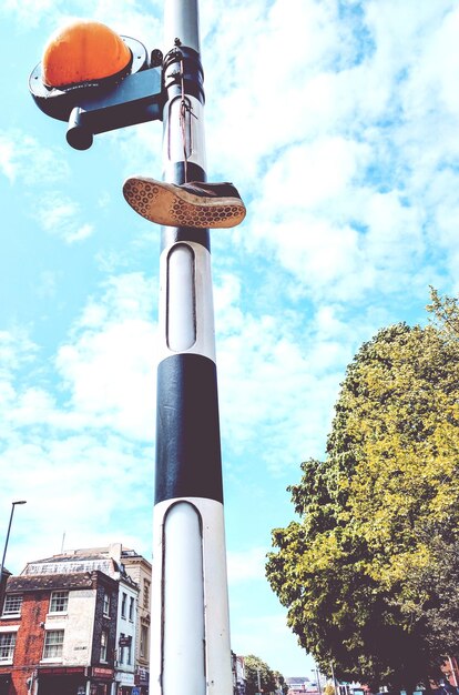 A close-up of a smart city sensor mounted on a streetlight, measuring air quality, with blurred city traffic in the background.
